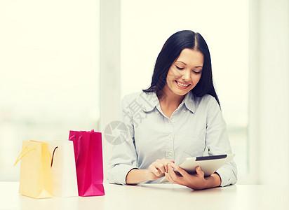 网上购物,电子产品小工具微笑的女人与空白屏幕平板电脑购物袋图片